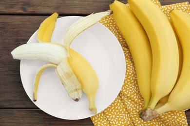 Many delicious ripe bananas on wooden table, flat lay