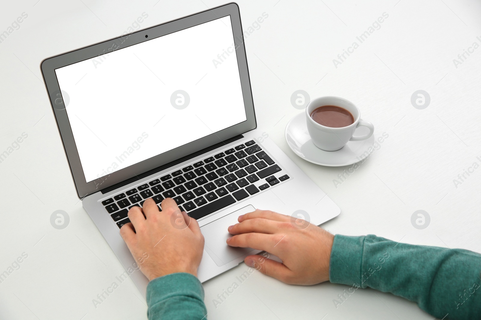 Photo of Young man working with modern laptop at table, closeup. Mockup for design