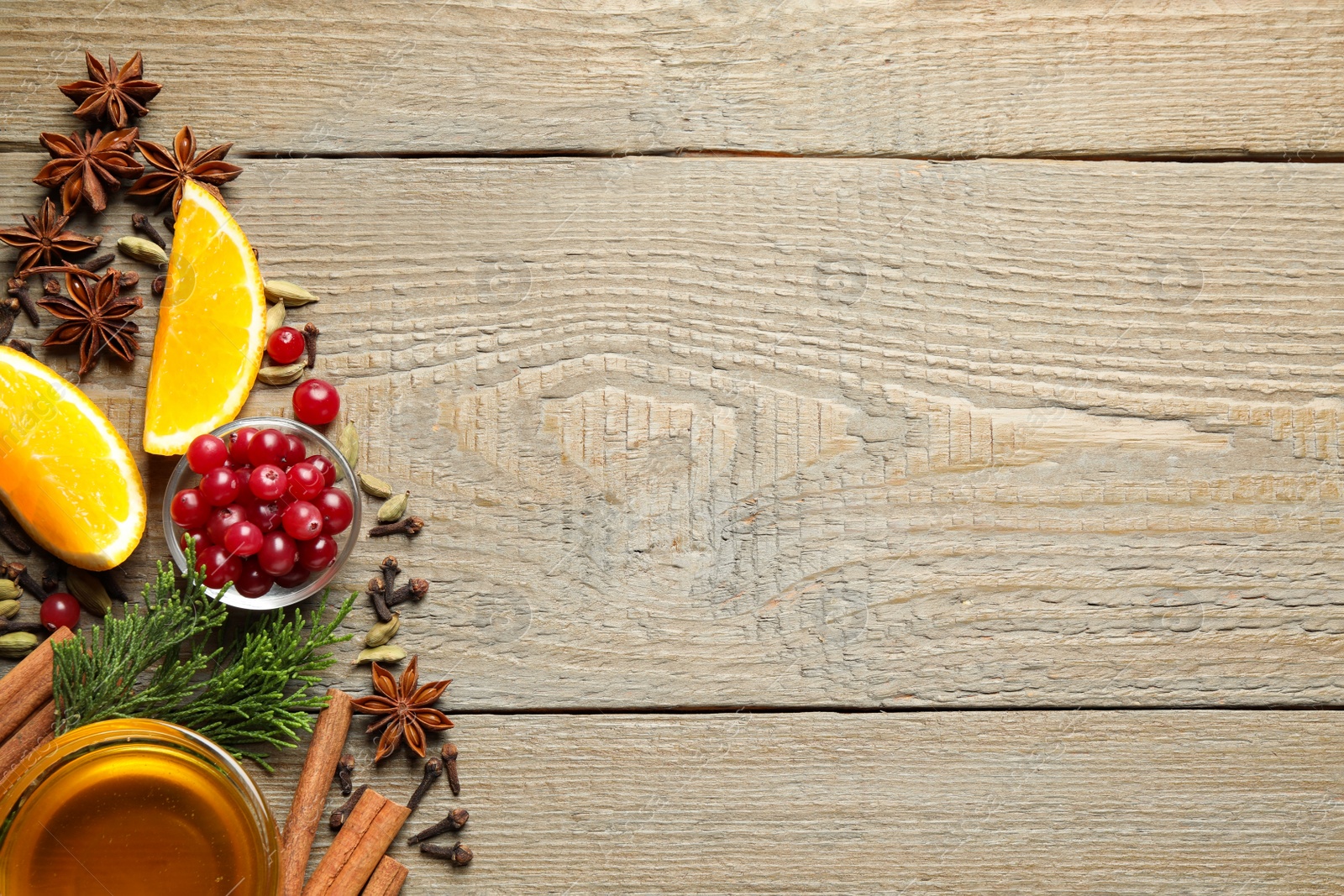 Photo of Flat lay composition with mulled wine ingredients on wooden table. Space for text