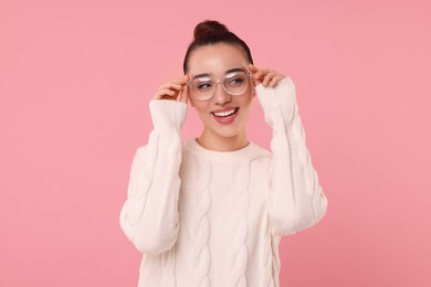 Photo of Beautiful young woman in stylish warm sweater on pink background