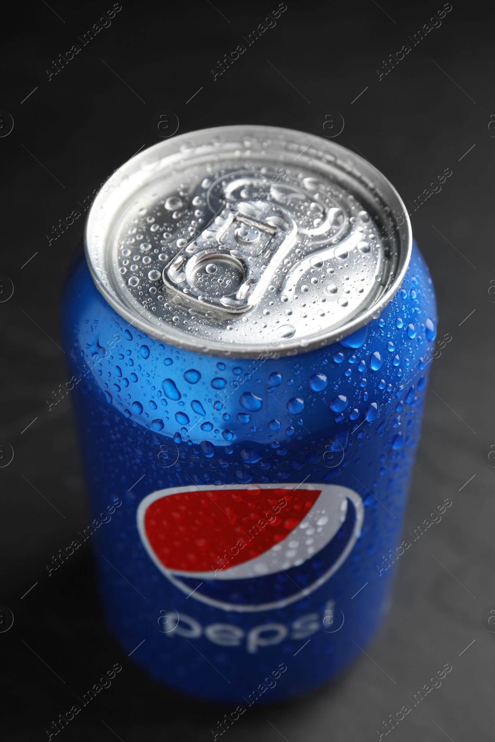 Photo of MYKOLAIV, UKRAINE - FEBRUARY 08, 2021: Can of Pepsi with water drops on black table, closeup