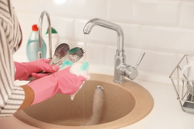 Woman doing washing up in kitchen sink, closeup view. Cleaning chores