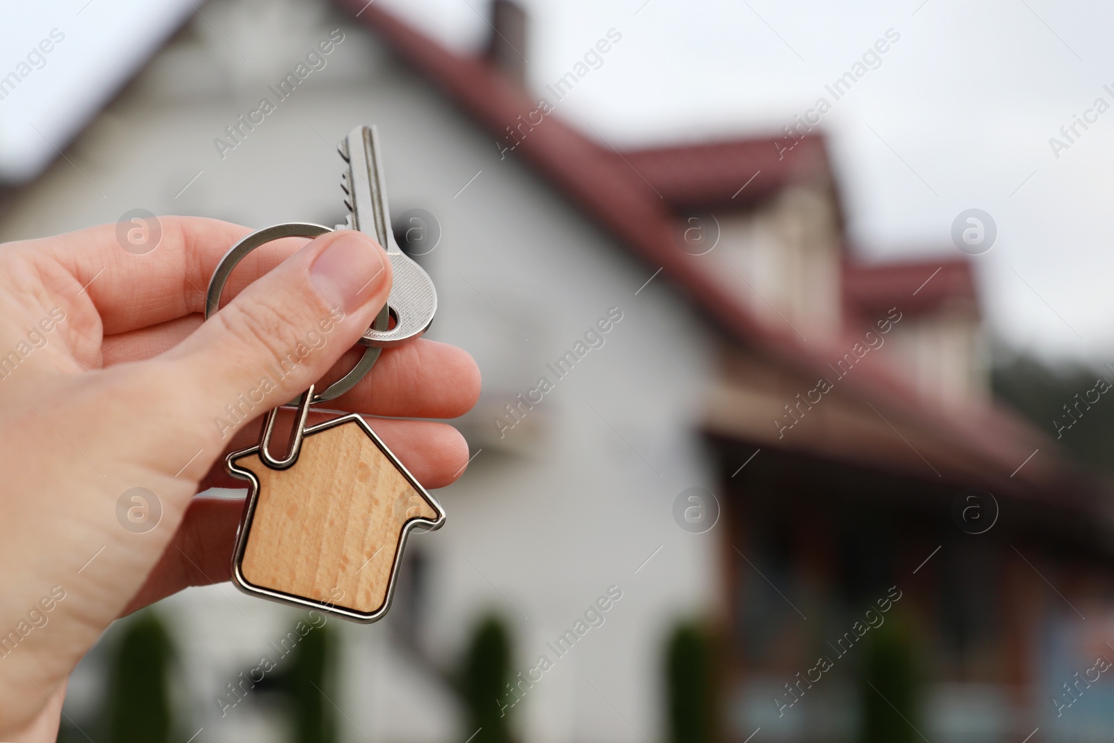 Photo of Woman holding house keys outdoors, closeup with space for text. Real estate agent