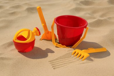 Photo of Set of plastic beach toys on sand. Outdoor play