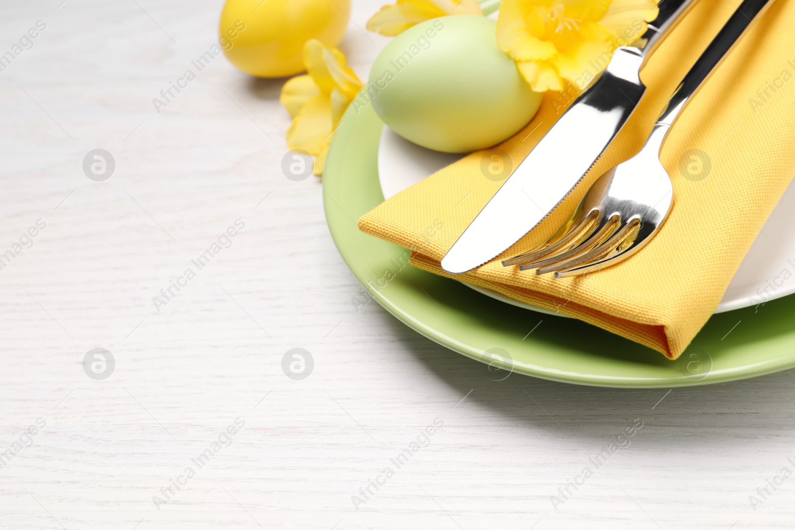 Photo of Festive Easter table setting with eggs on white wooden background, closeup. Space for text