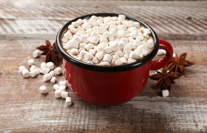 Tasty hot chocolate with marshmallows on wooden table, closeup