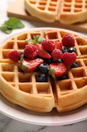 Photo of Tasty Belgian waffle with fresh berries on table, closeup