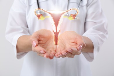 Image of Doctor and illustration of female reproductive system on white background, closeup