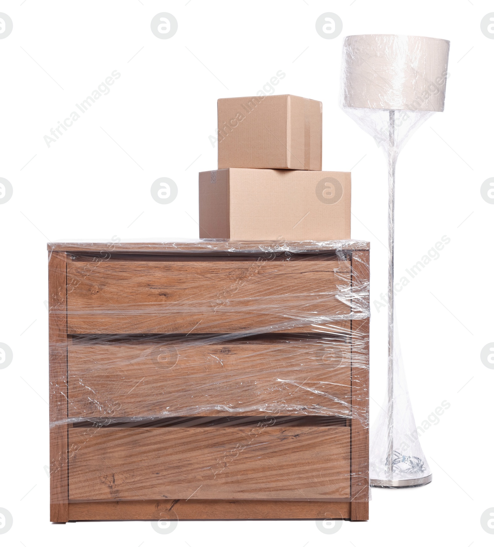 Photo of Boxes, lamp and chest of drawers wrapped in stretch film on white background