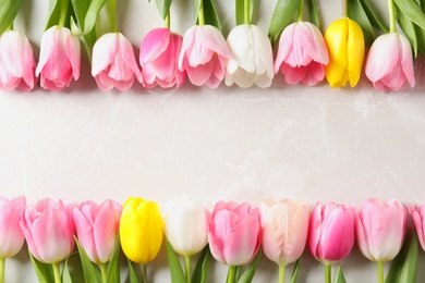 Photo of Flat lay composition of beautiful tulips  on marble background, space for text. International Women's Day