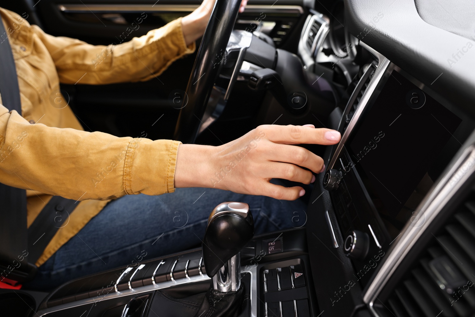 Photo of Woman using navigation system while driving her car, closeup