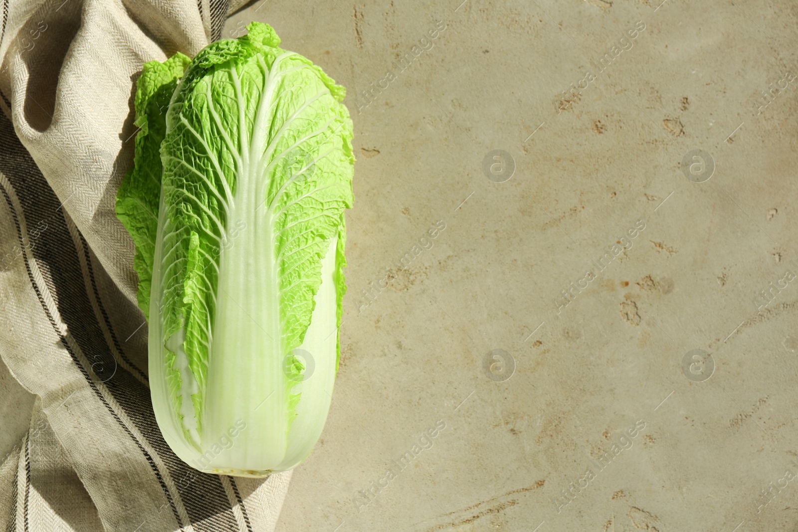 Photo of Fresh ripe Chinese cabbage on gray textured table, top view. Space for text