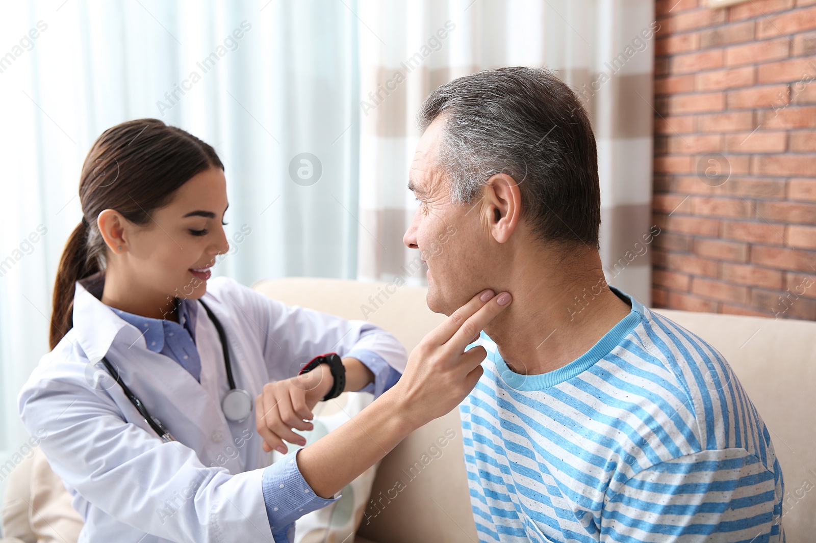 Photo of Doctor checking mature man's pulse with fingers indoors