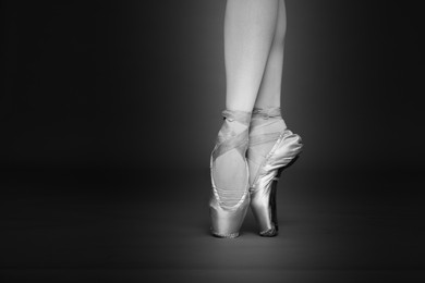 Image of Ballerina in pointe shoes dancing, closeup with space for text. Black and white effect