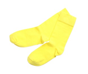Photo of Pair of yellow socks on white background, top view