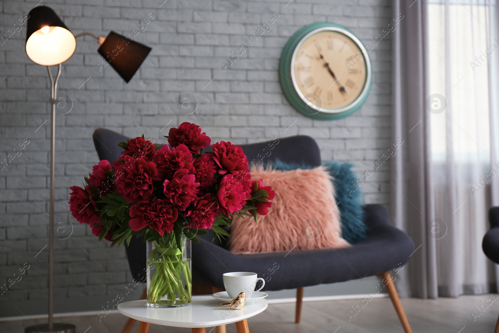 Photo of Elegant living room interior with comfortable sofa and beautiful flowers