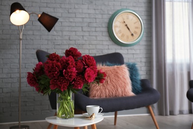 Elegant living room interior with comfortable sofa and beautiful flowers