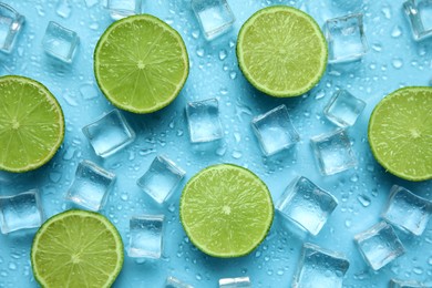 Photo of Ice cubes and cut limes on turquoise background, flat lay. Ingredients for refreshing drink