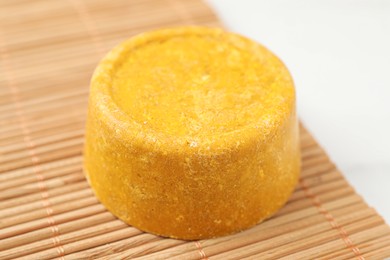 Yellow solid shampoo bar on light table, closeup