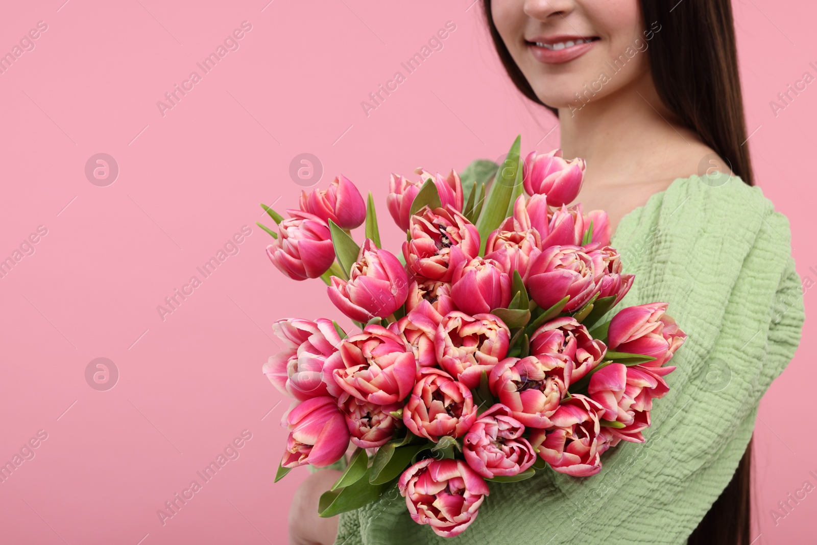 Photo of Happy woman with beautiful bouquet on dusty pink background, closeup