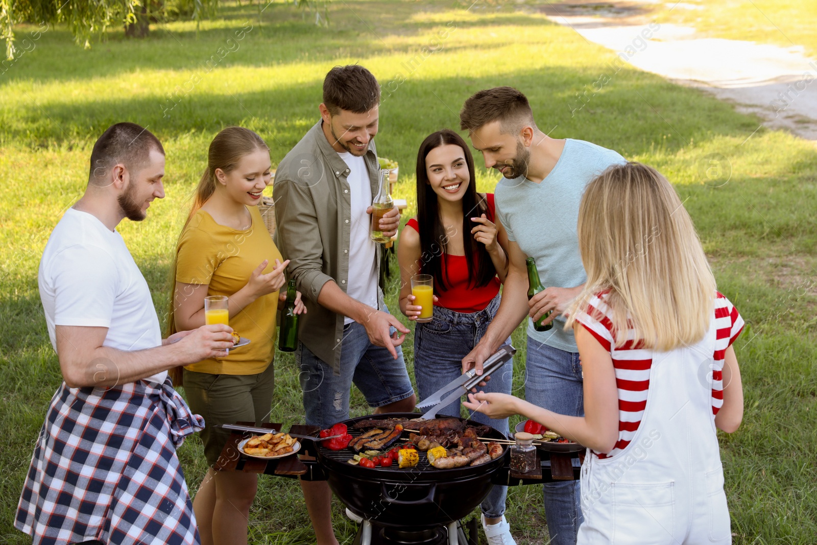 Photo of Group of friends having barbecue party in park