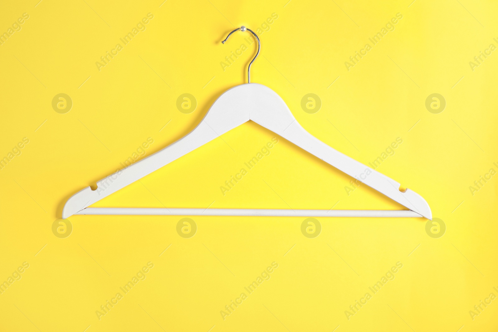 Photo of Empty clothes hanger on color background. Wardrobe accessory