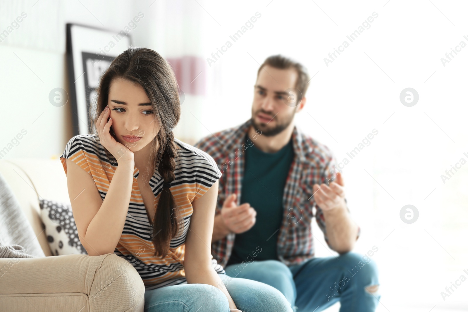 Photo of Young couple having argument in living room