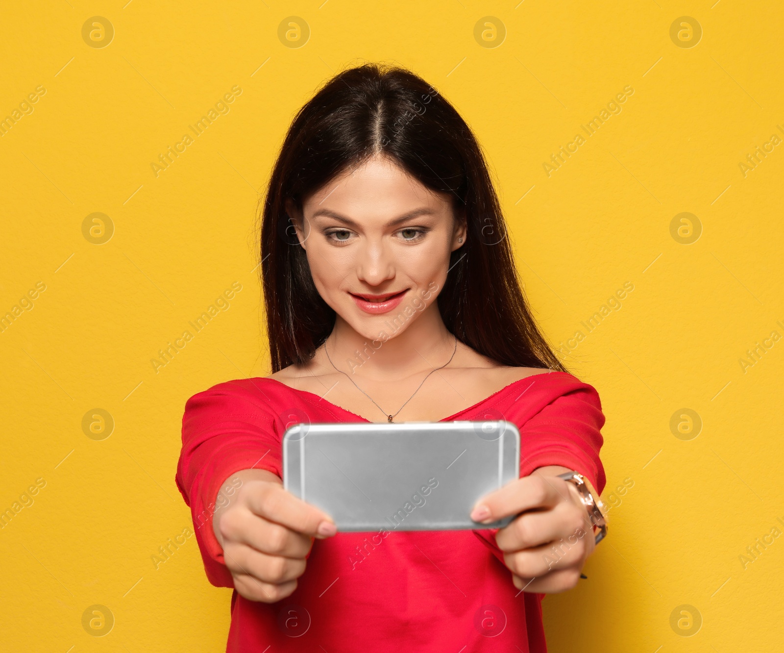 Photo of Attractive young woman taking selfie on color background