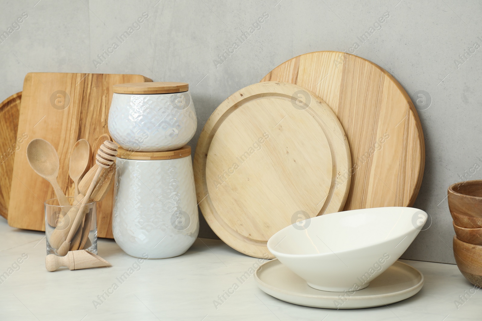 Photo of DIfferent wooden cutting boards and other cooking utensils on white countertop in kitchen