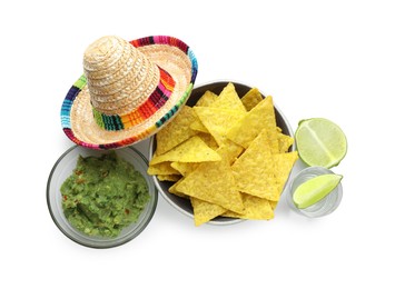 Photo of Mexican sombrero hat, tequila with lime, nachos chips and guacamole in bowls isolated on white, top view