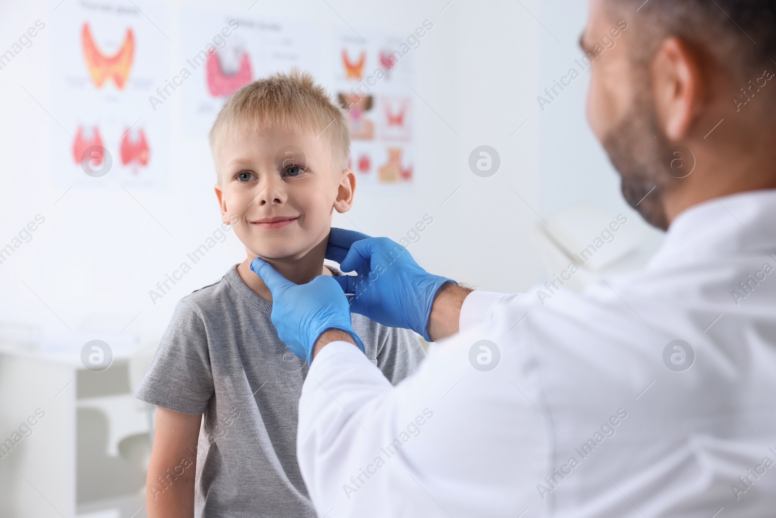 Photo of Endocrinologist examining boy's thyroid gland at hospital