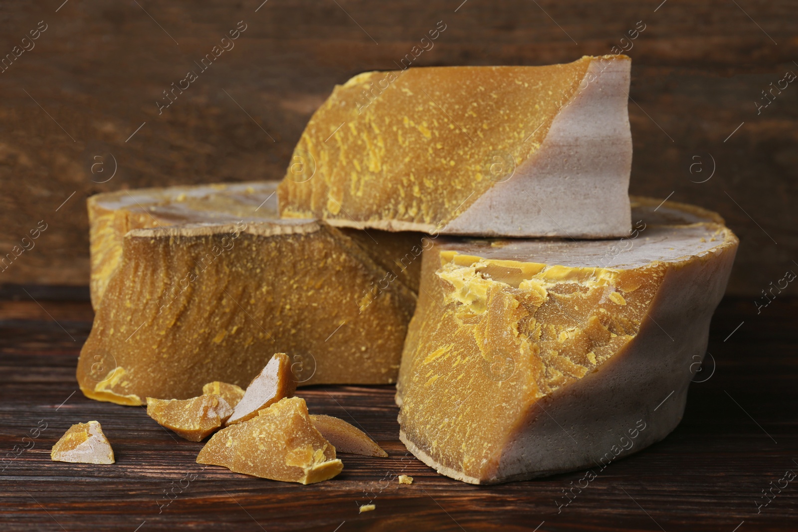 Photo of Natural organic beeswax blocks on wooden table, closeup