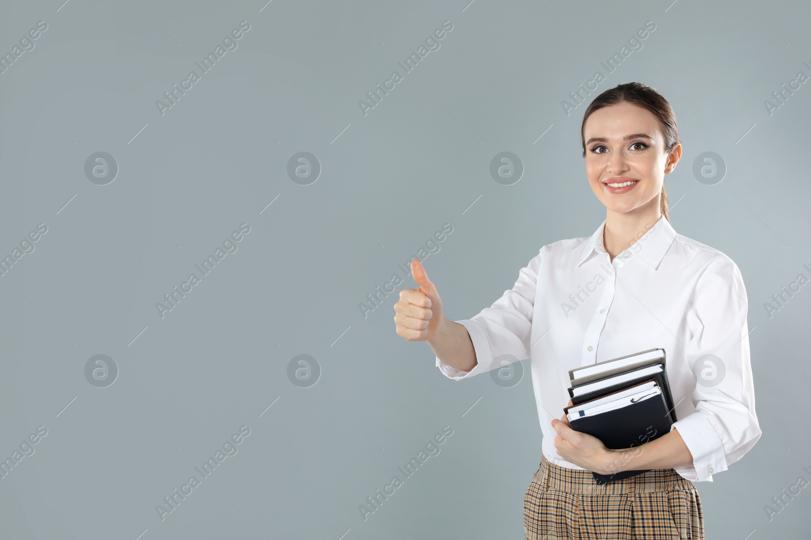 Photo of Portrait of young female teacher on grey background. Space for text