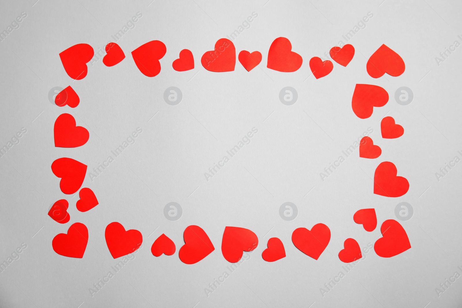 Photo of Frame made of small paper hearts on white background