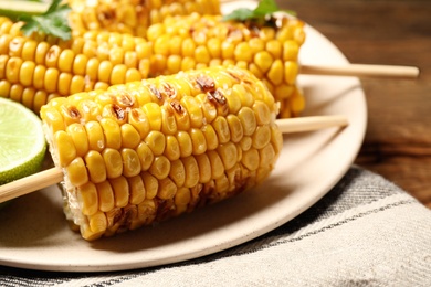 Photo of Tasty grilled corn on table, closeup view