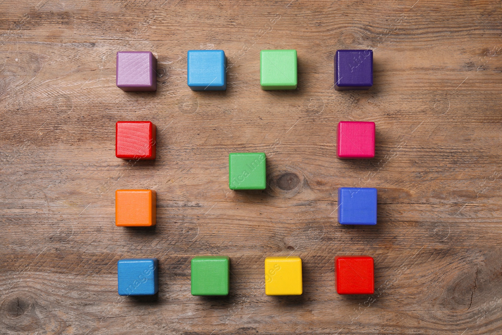 Photo of Blank colorful cubes on wooden table, flat lay