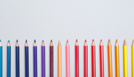Photo of Colorful pencils on light background, flat lay. Space for text