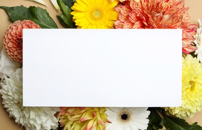 Photo of Flat lay composition with beautiful dahlia flowers and blank card on beige background, flat lay. Space for text