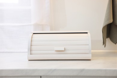 Photo of Wooden bread box on white countertop in kitchen