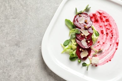 Photo of Plate with delicious beet salad on grey background, top view