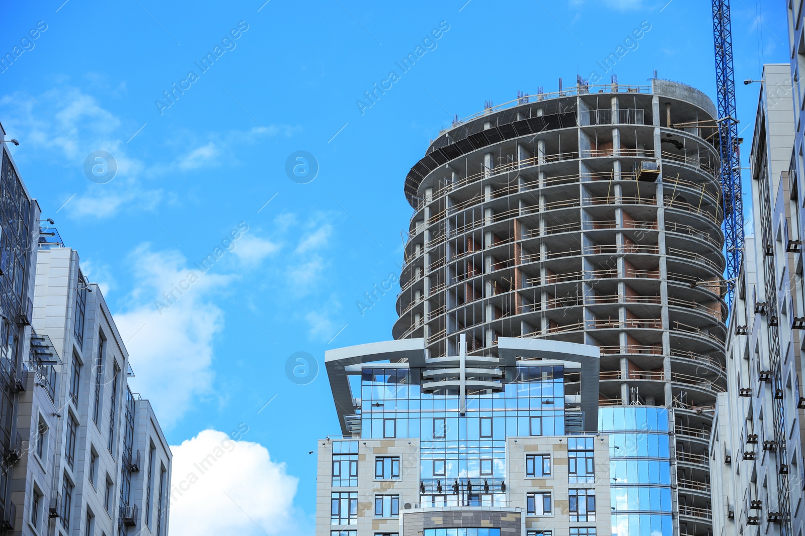 Photo of Unfinished building against blue sky. Construction safety rules