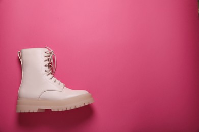 Stylish leather shoe on pink background, top view. Space for text