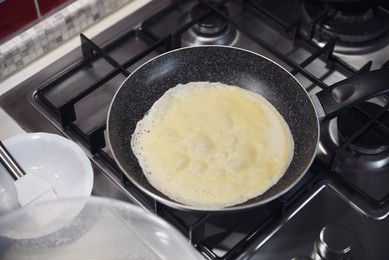 Photo of Frying delicious crepe on pan in kitchen