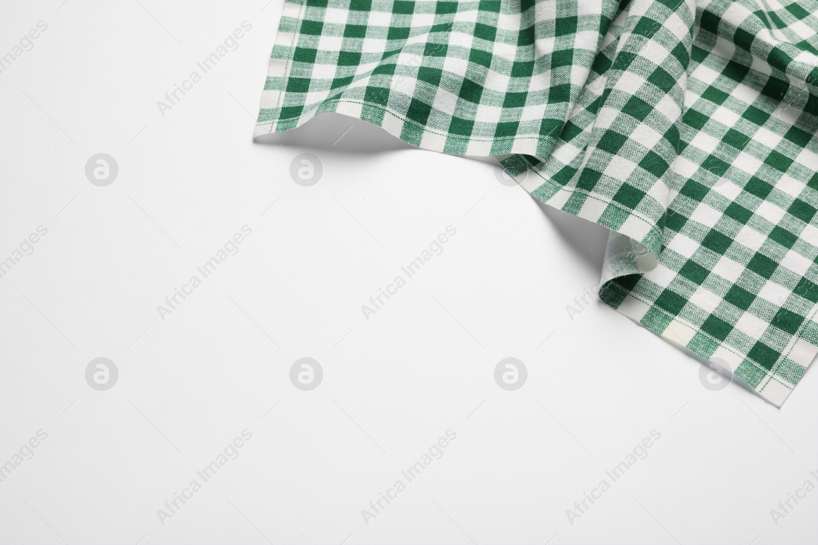 Photo of New green checkered tablecloth on white background