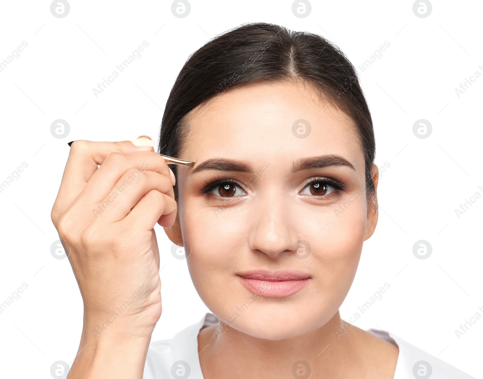 Photo of Young woman plucking eyebrow with tweezers on white background