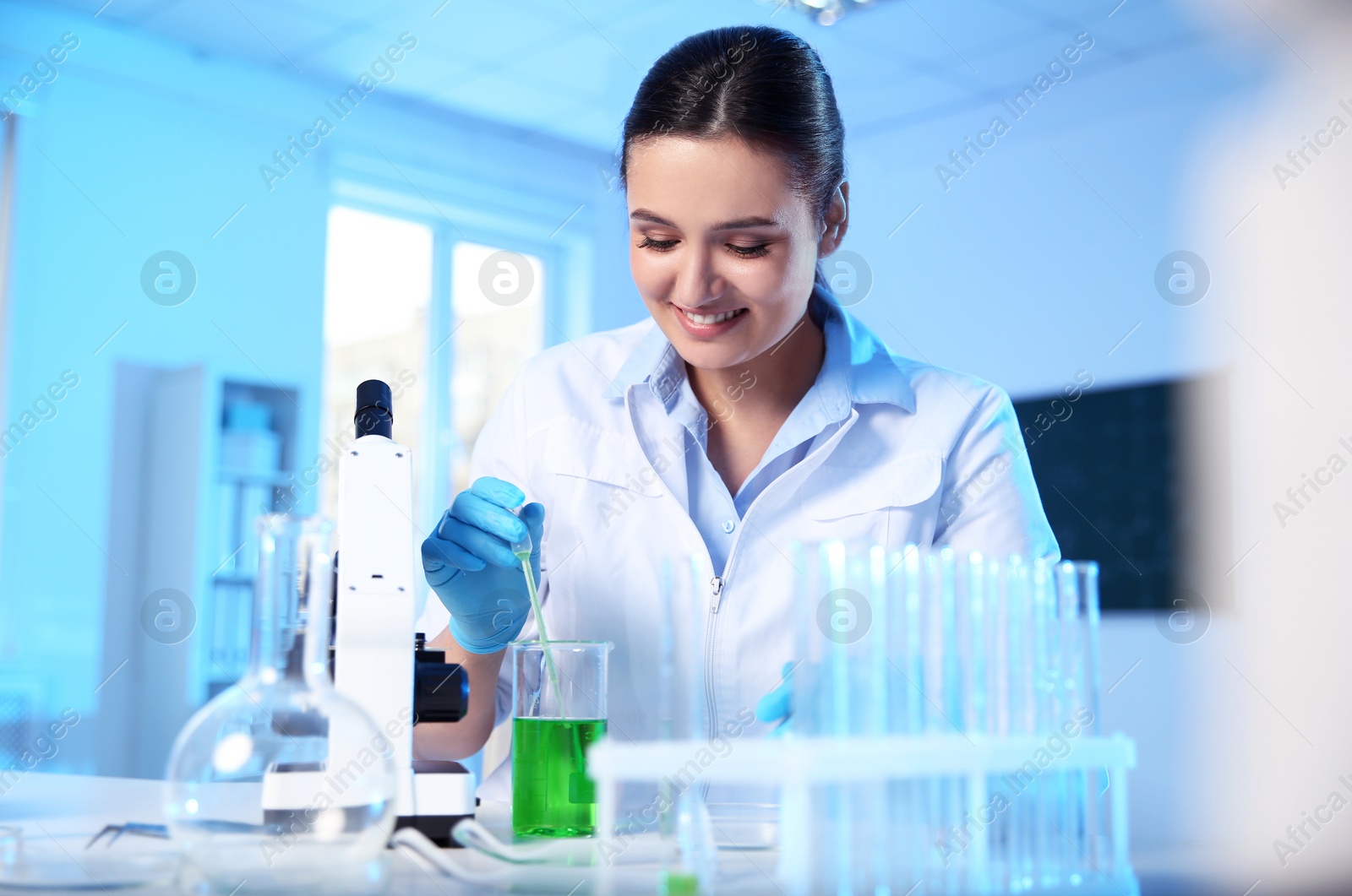 Photo of Female scientist working with sample in modern chemistry laboratory