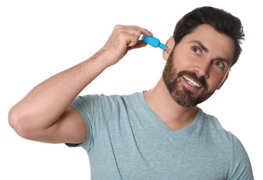 Man using ear drops on white background