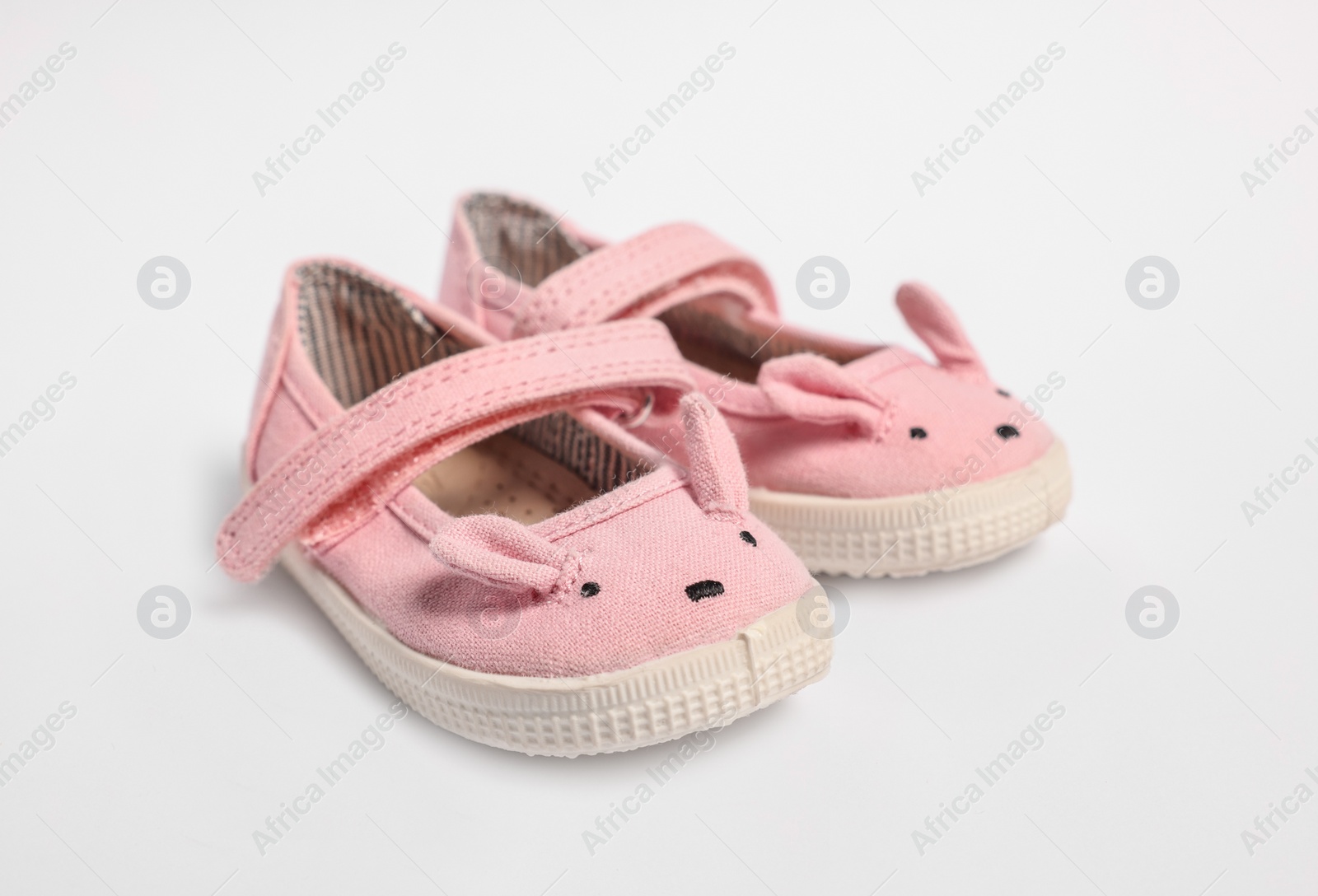 Photo of Pair of cute baby shoes on white background