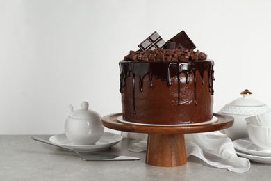 Freshly made delicious chocolate cake on grey table against white background. Space for text