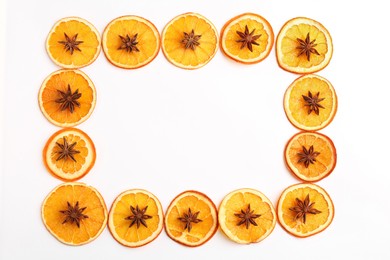 Frame made of dry orange slices and anise stars on white background, flat lay. Space for text